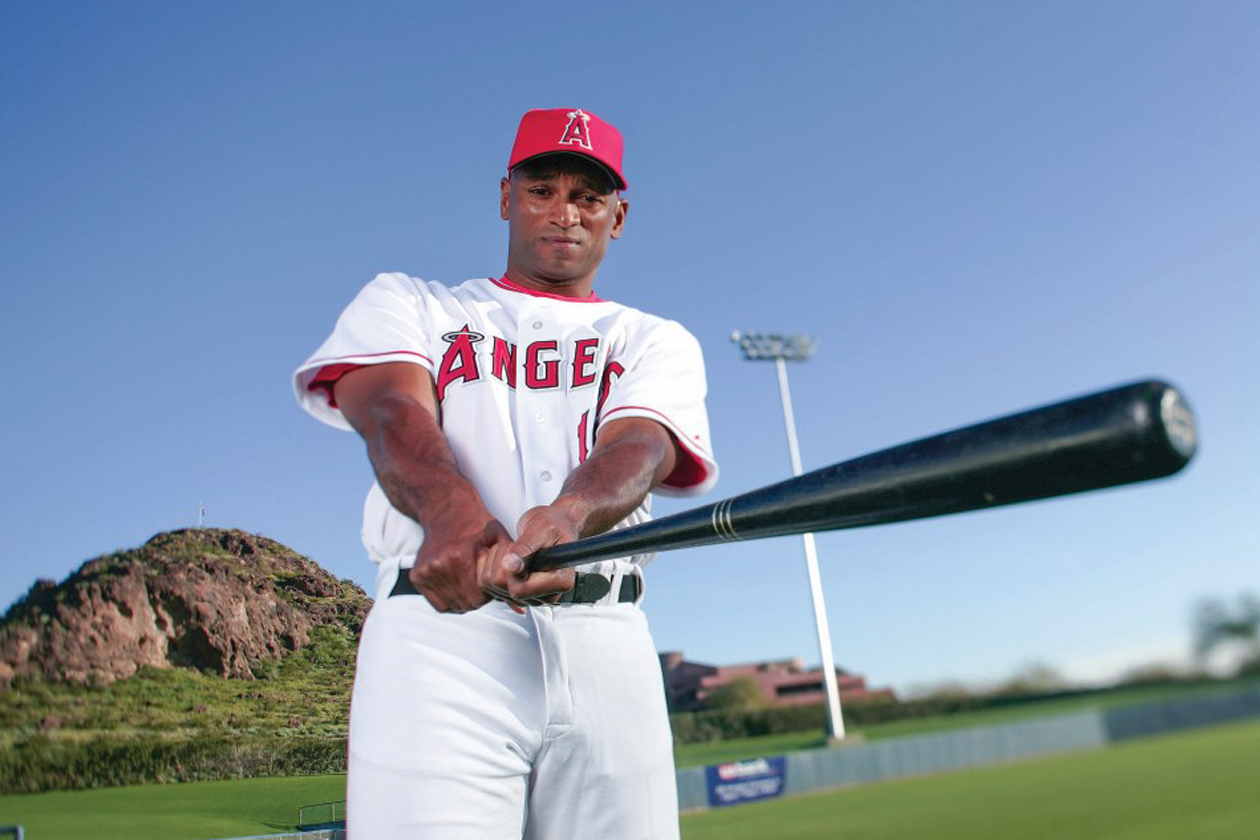 Curtis Pride holds a baseball bat while wearing an Angels uniform.